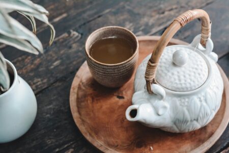 white and brown ceramic teapot on wooden tray