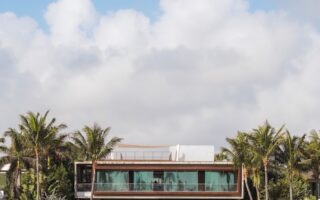 white and brown concrete building near green trees under white clouds and blue sky during daytime